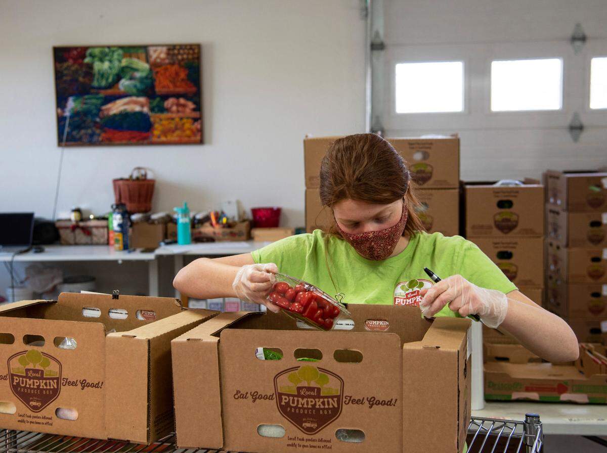Annie Franklin, daughter of Local Pumpkin owners Cathy and John Franklin, prepares produce boxes for delivery. The Pasco business has seen a spike in demand for their produce and milk product boxes since the start of the coronavirus outbreak.