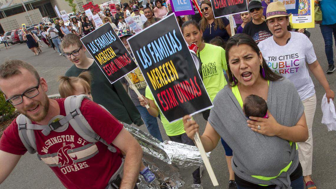Luke Hallowell, left, and Jazmin Santacruz-Hallowell rally with other protesters Saturday at John Dam Plaza in Richland. The protest was against federal policy that separates children from their parents at the southern border.