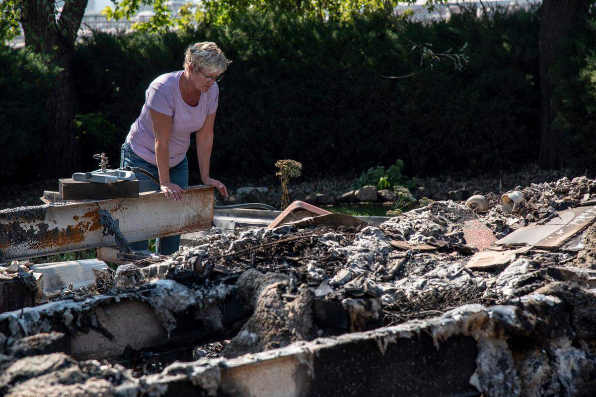 Lavonne Boogerd looks for keepsakes in the charred remains of her house in Prosser which burned down during a fire on Labor Day.