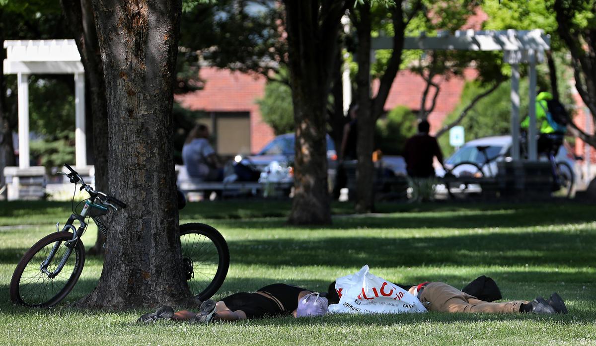 People sleep and gather in Pasco’s Volunteer Park near the Franklin County Courthouse and Pasco City Hall.