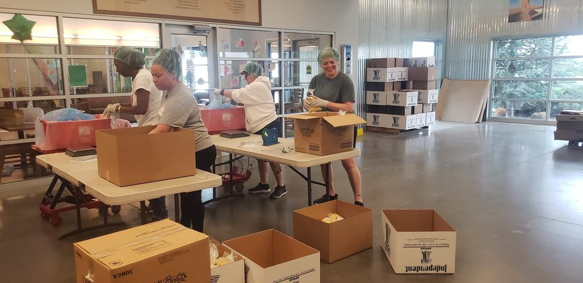 Second Harvest volunteers separate bulk corn into smaller packages before distribution