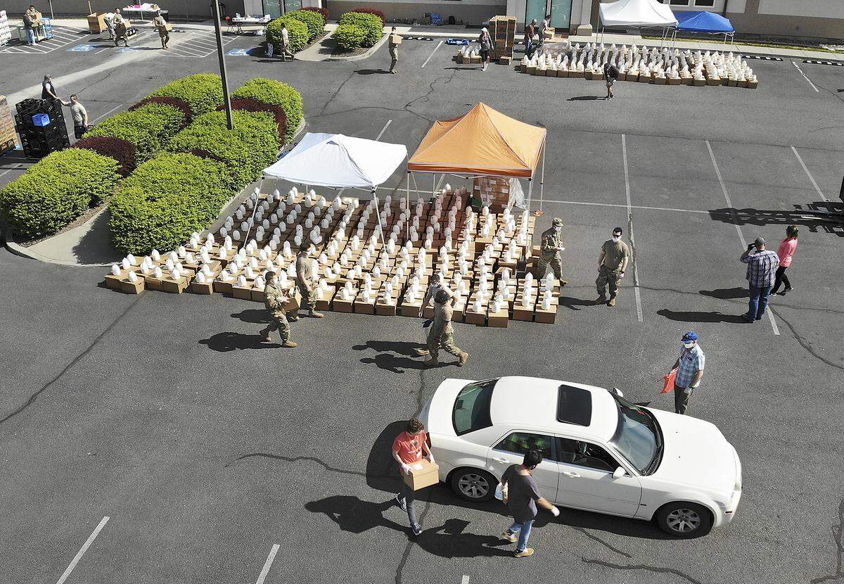 Twenty-five members of the Air and Army National Guard work alongside about 50 Bethel Church volunteers distributing boxes of food and containers of milk in the parking lot of the South Richland church off Shockley Road last April.