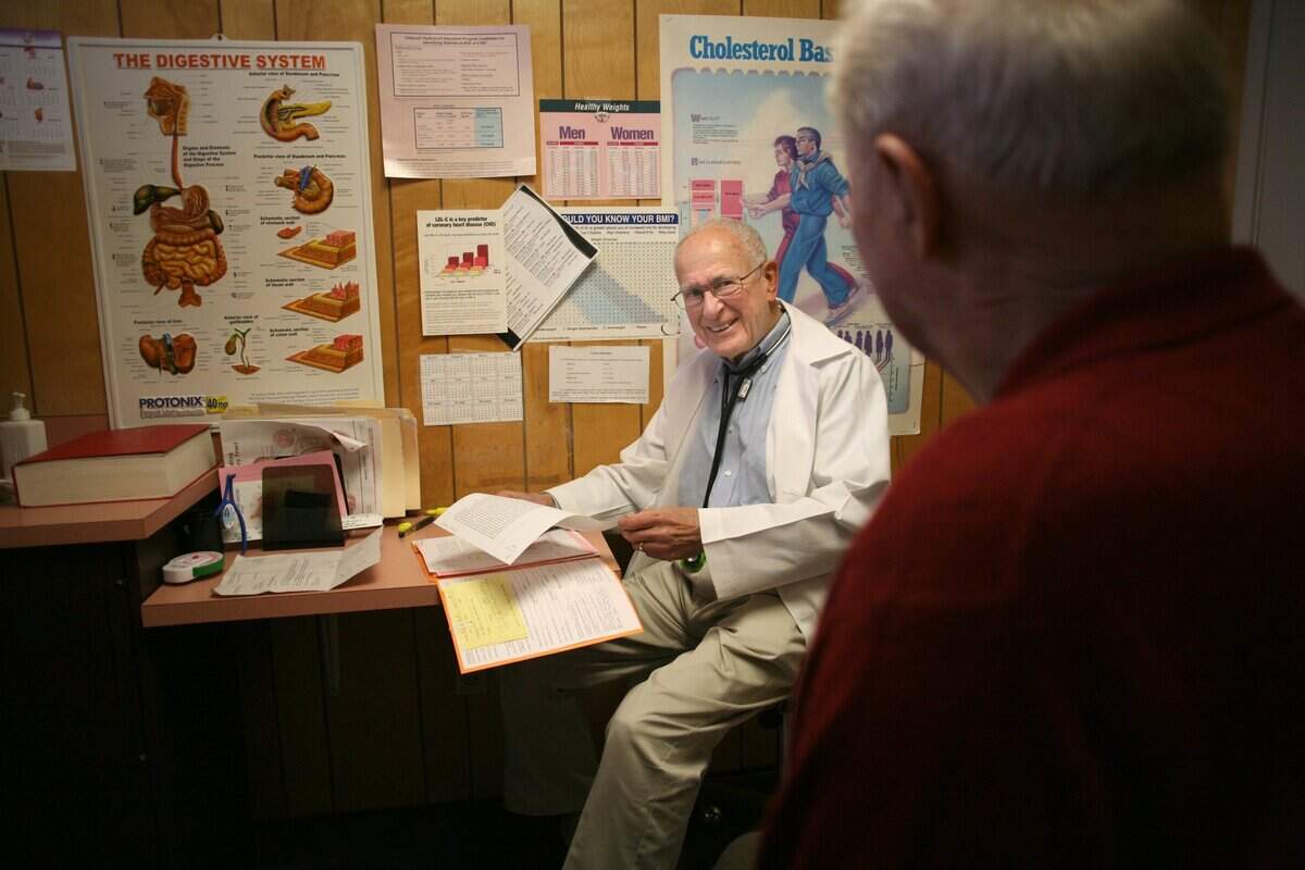 Dr. Rod Coler talks with a patient in 2006, his 48th year of practicing medicine in the Tri-Cities.