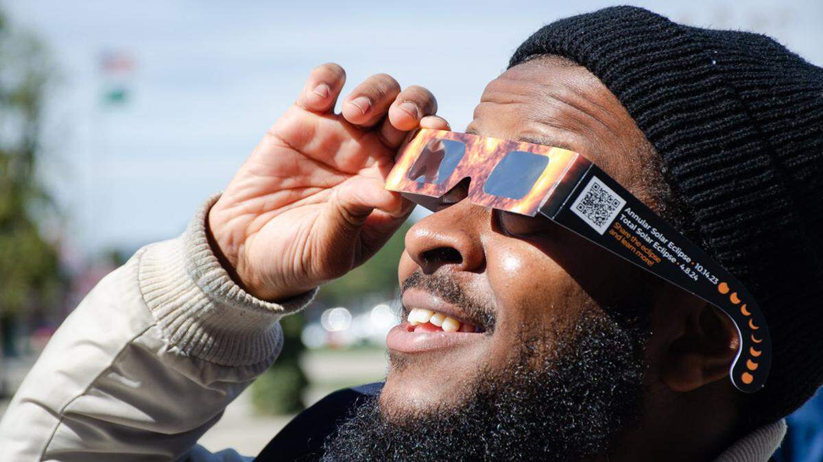 Kalid Hussein, a student at Columbia Basin College and a NASA Solar System Ambassador, watches Monday’s partial solar eclipse from the Pasco, Wash., campus. He helped distribute hundreds of solar eclipse glasses to CBC students so that they could watch the event.
