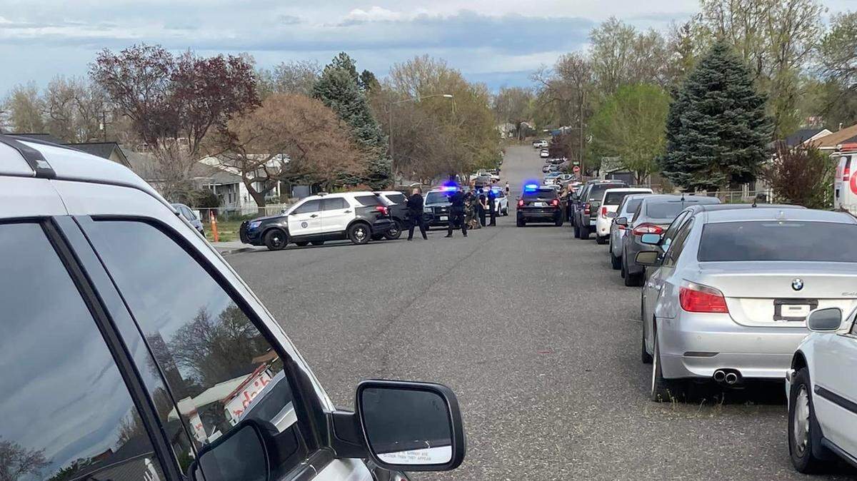 Kennewick police surrounded a home near the intersection of West Fifth Avenue and South Washington Street. Police were investigating it in connection with the April 20 fatal shooting of Ezekiel Sanchez.