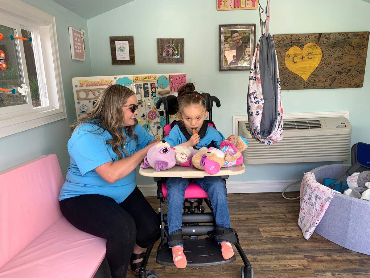 Finnley and Codi Couchman look at their new playhouse for the first time at a Wishing Star Foundation wish granting event.