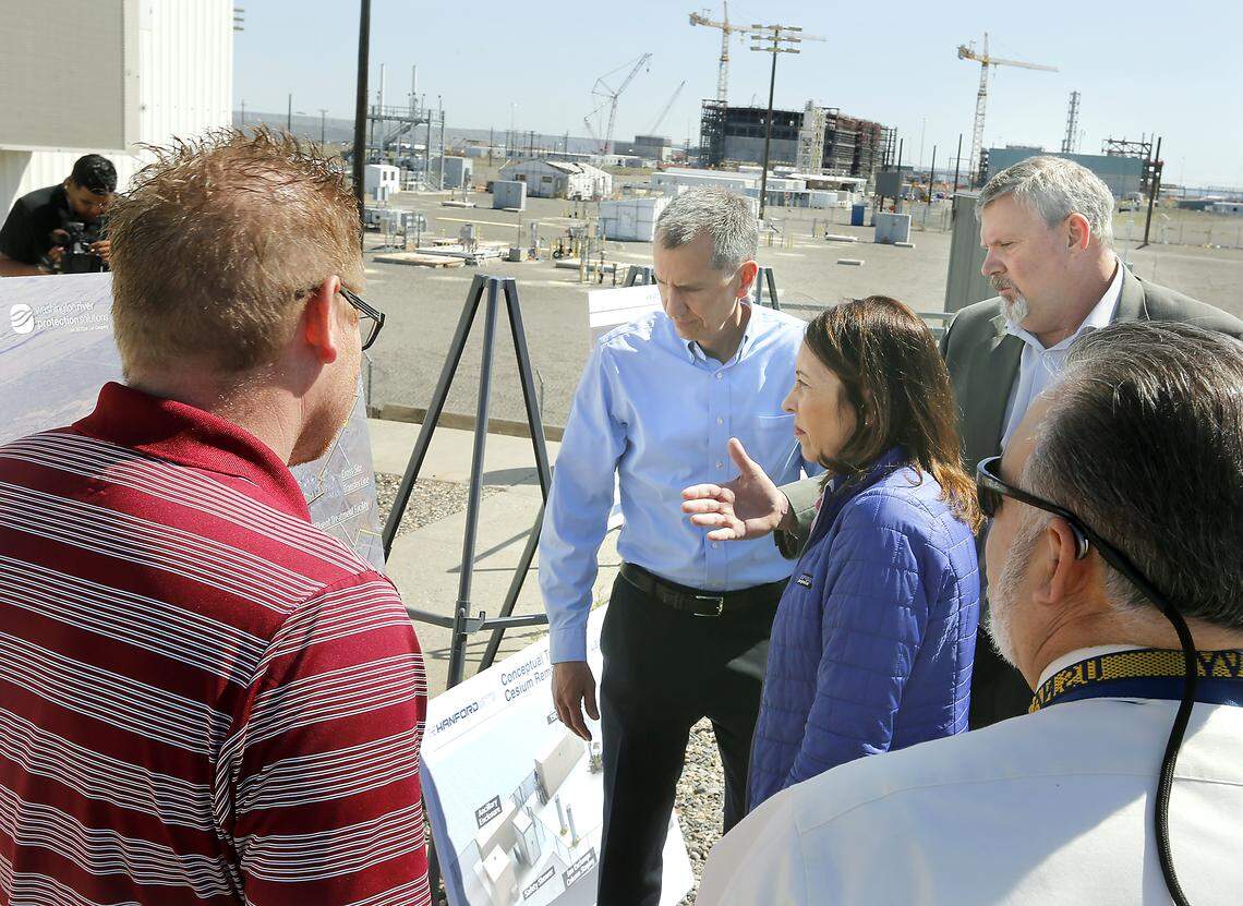Sen. Maria Cantwell learns about new monitoring technology being used for improved worker safety at Hanford from DOE Hanford Manager Brian Vance, center, and Brian Hart, right, DOE deputy manager of Office of River Protection. The Hanford Vitrification Plant is visible in the background. Watch a video at: tricityherald.com/video
