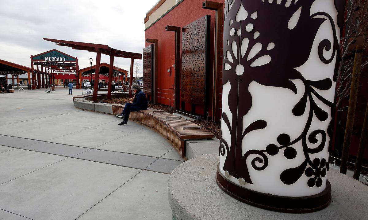 Vicki Gordon uses her smartphone while using the new seating area in the newly renovated Peanuts Park in downtown Pasco prior to Friday’s ribbon cutting ceremony for the project that also includes the Farmers Market.