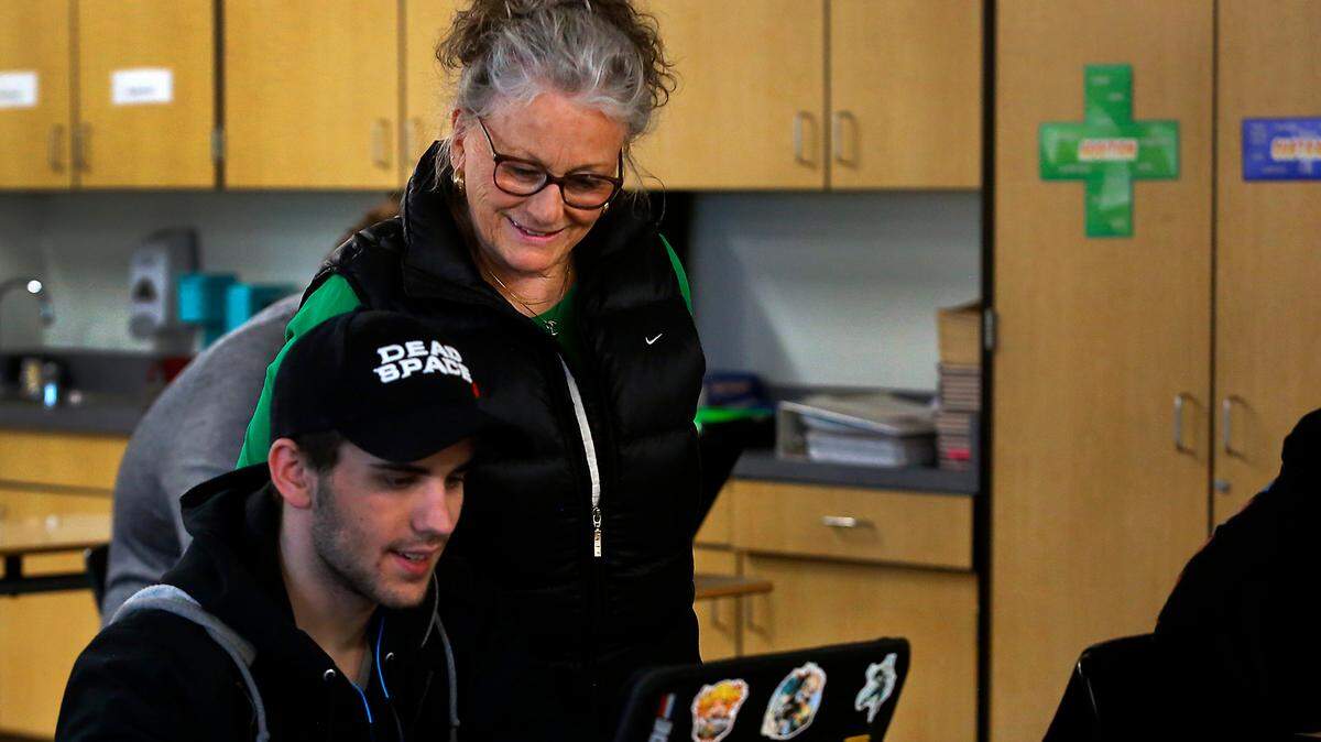 Special education paraeducator Nan Duncan helps Richland High student George Murray in this 2023 file photo. The Washington Legislature is considering pay increases for paraeducators statewide.