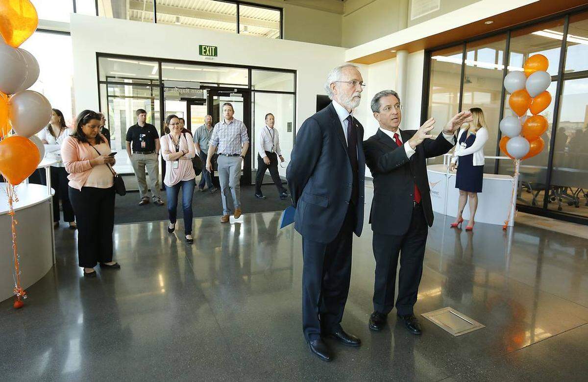 PNNL Director Steven Ashby, right, greets Rep. Dan Newhouse, R-Wash., in the hallway of the new 24,000-square-foot Discovery Hall during the April dedication ceremony of the new $9.8 million building at the Richland research facility.