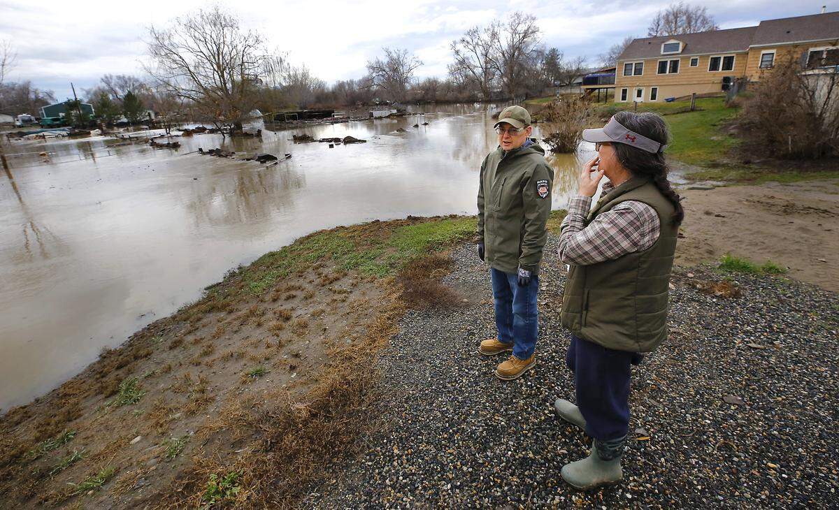 Cheryl and Stuart Arm look at the submerged pasture at their home at 1767 Buckskin Lane Monday morning as the Yakima River floodwaters recede after cresting over the weekend. 