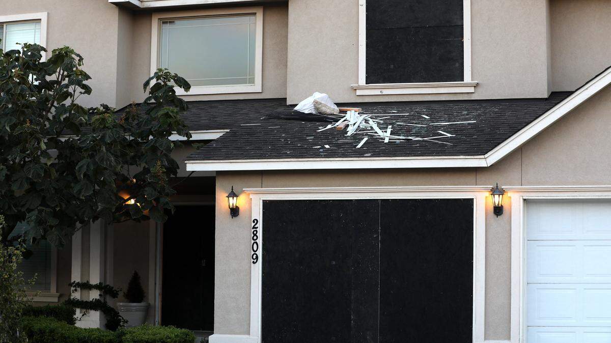 The Kennewick home on South Dawes Street has a couple doors and window boarded over after Kennewick police discovered three bodies inside.