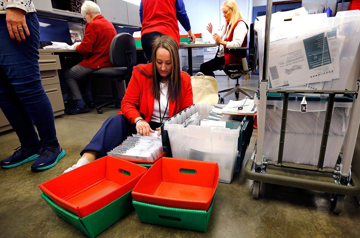 Shannon Kimball, Franklin County assistant elections manager, sits on the floor of the Franklin County Election Center building to organize ballots for date stamping and verification on Election Day. 