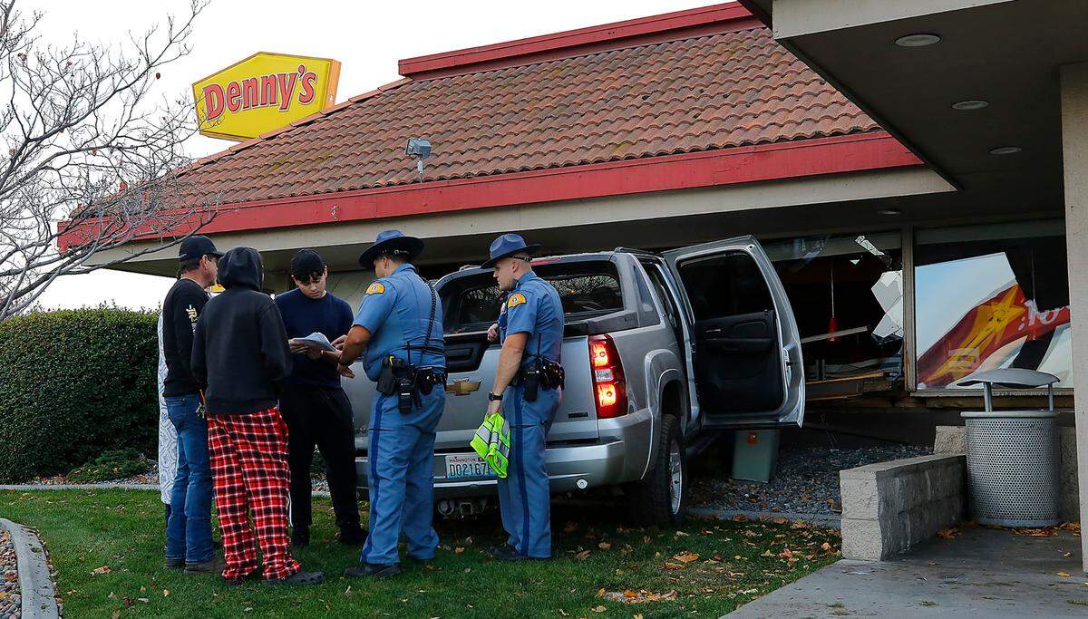 Washington State Patrol Trooper Anselmo Sanchez talks with a diver of a Chevrolet Avalanche pickup that crashed into the Denny’s restaurant in Kennewick.