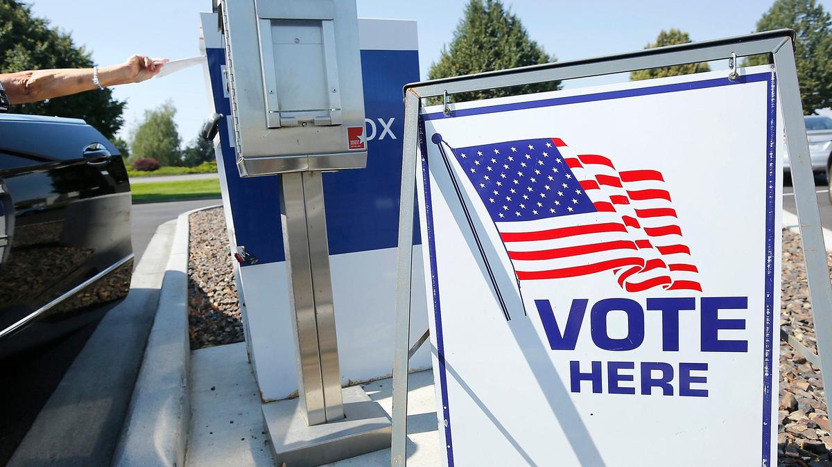 A Benton County voter drops off her ballot at a drop box in Kennewick. 