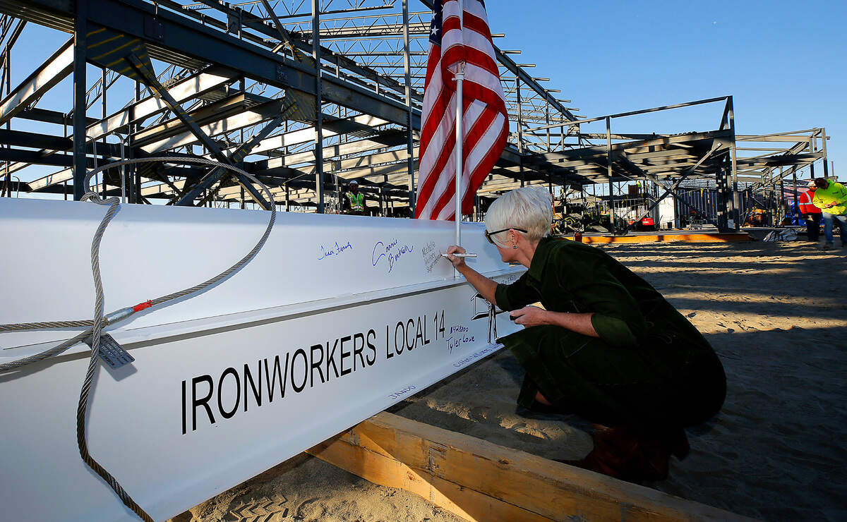 Pasco school superintendent Michelle Whitney signs the front of the final steel beam for the Orion High School construction project for the topping off ceremony.