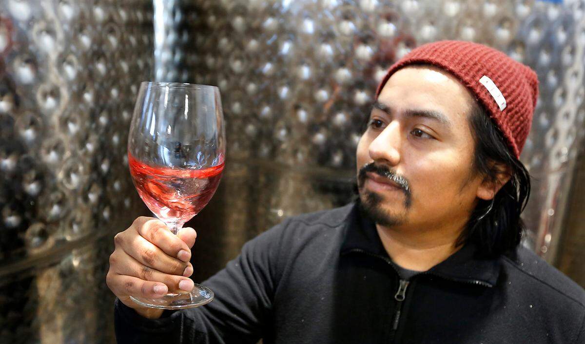 Winemaker Noah Perez, 31, holds a glass of wine he’s currently making in shared space at Monarcha Winery at the Columbia Village Winery & Artisan Village in downtown Kennewick on Columbia Drive.