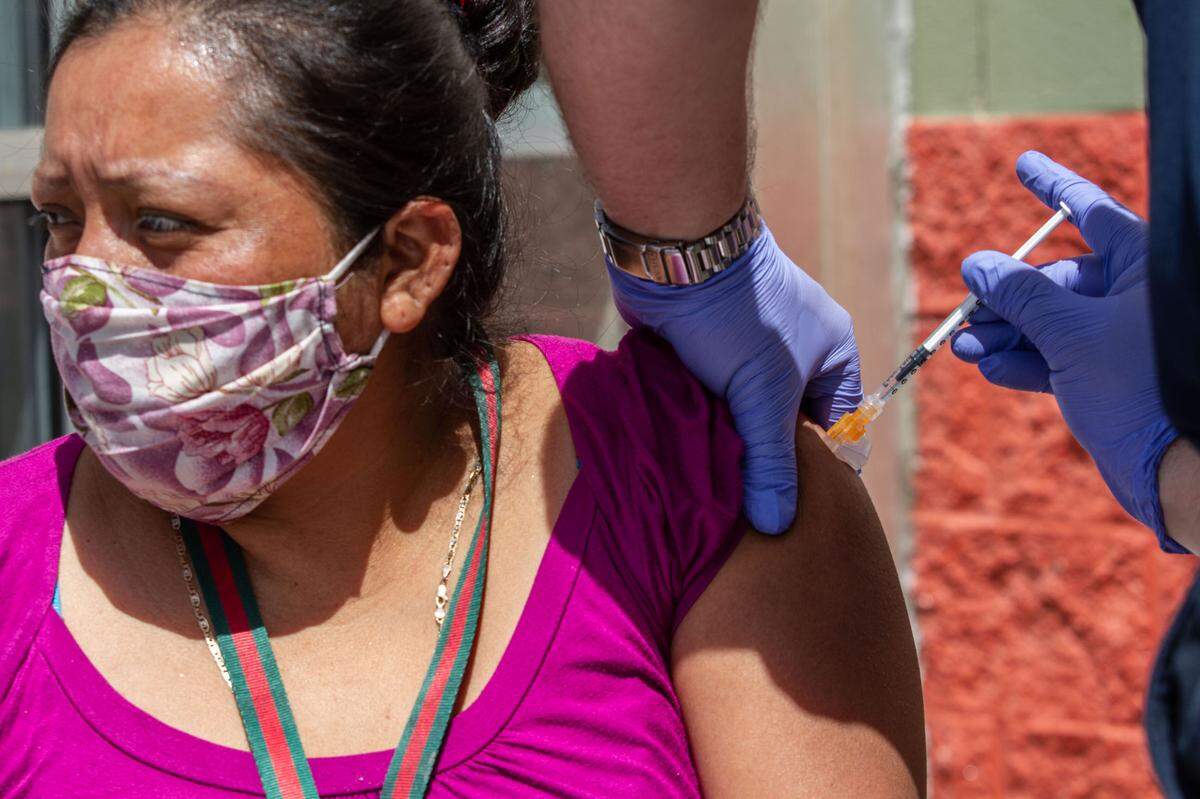 Alma Santiago, 37, of Kennewick, gets a shot at a pop-up vaccine clinic outside of Fiesta Foods in Pasco. “It’s free so I took advantage of the opportunity,” she said in Spanish.