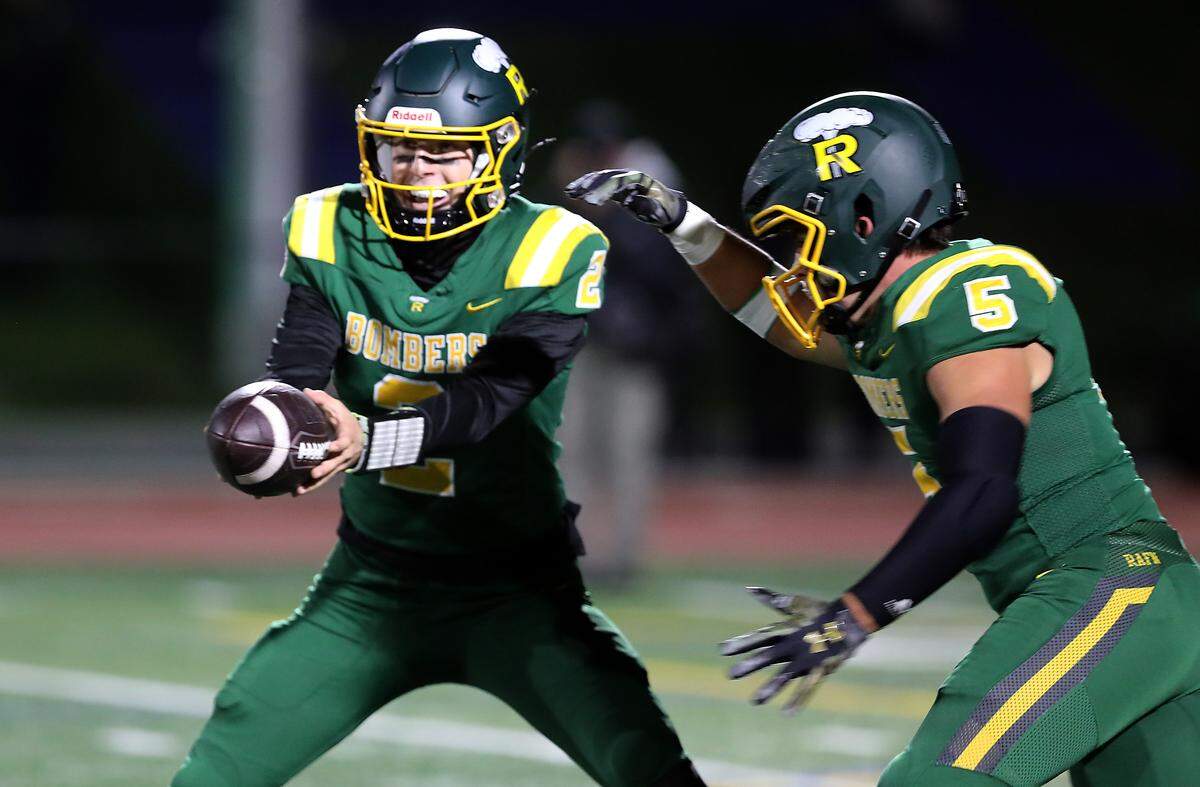 Richland quarterback Jackson Woodard hands off the ball to running back Tucker Watkins during their game in Richland on Oct. 30, 2025. Richland won 15-14 to clinch 2nd seed for the playoffs.