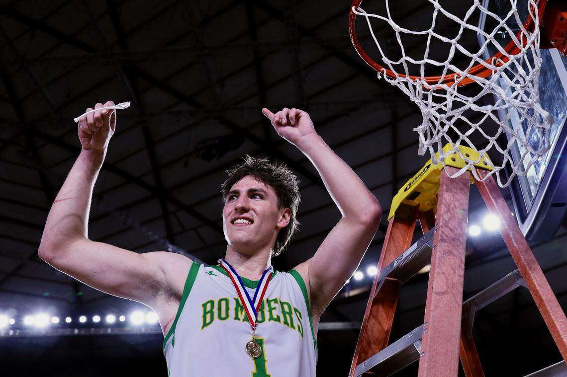 Richland’s Landen Northrop cuts a piece of the net during post game celebrations after the Bombers defeated Gonzaga Prep.