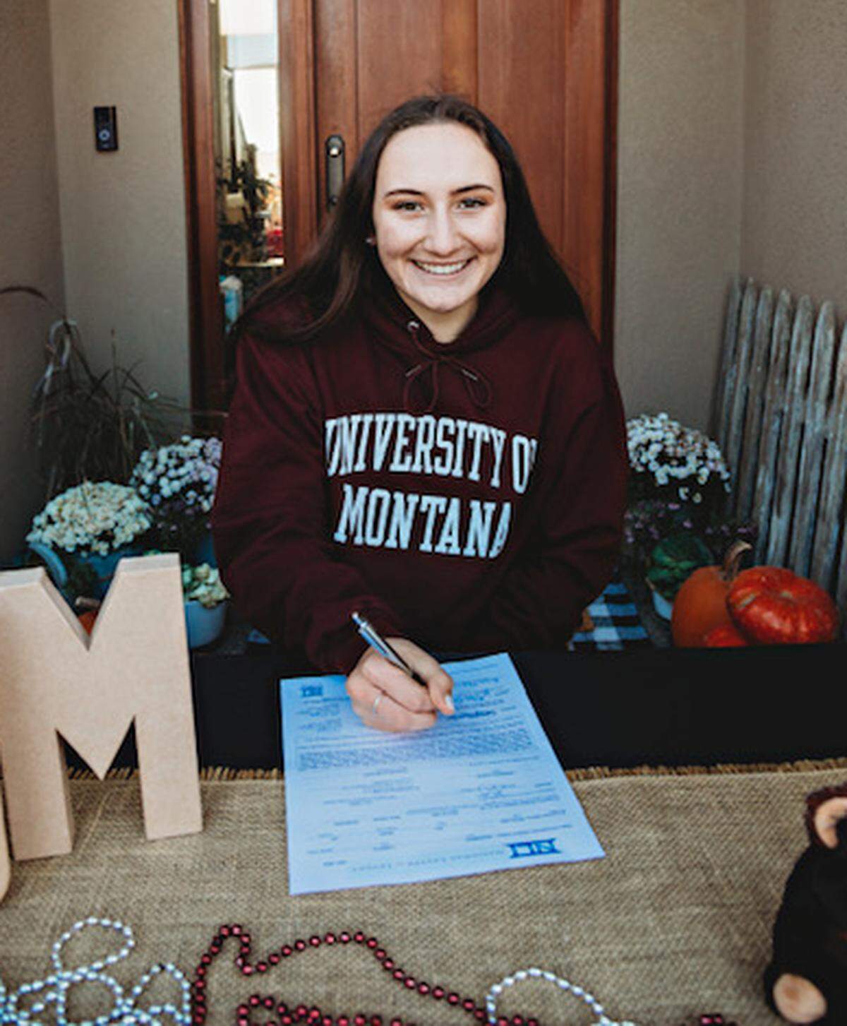 Hanford High senior Camryn Dezember signed a national letter of intent to run track for the University of Montana.