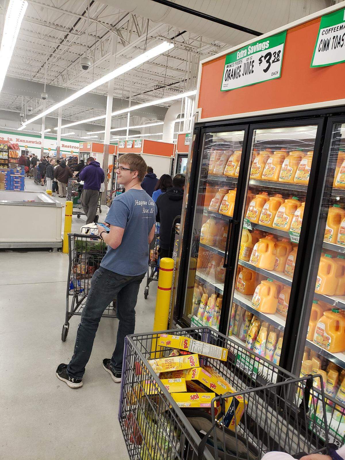 Lines at Winco in Kennewick wound through the store Thursday night as shoppers were stocking up on groceries. This shopper was apparently particularly concerned about a run on Corn Pops cereal.