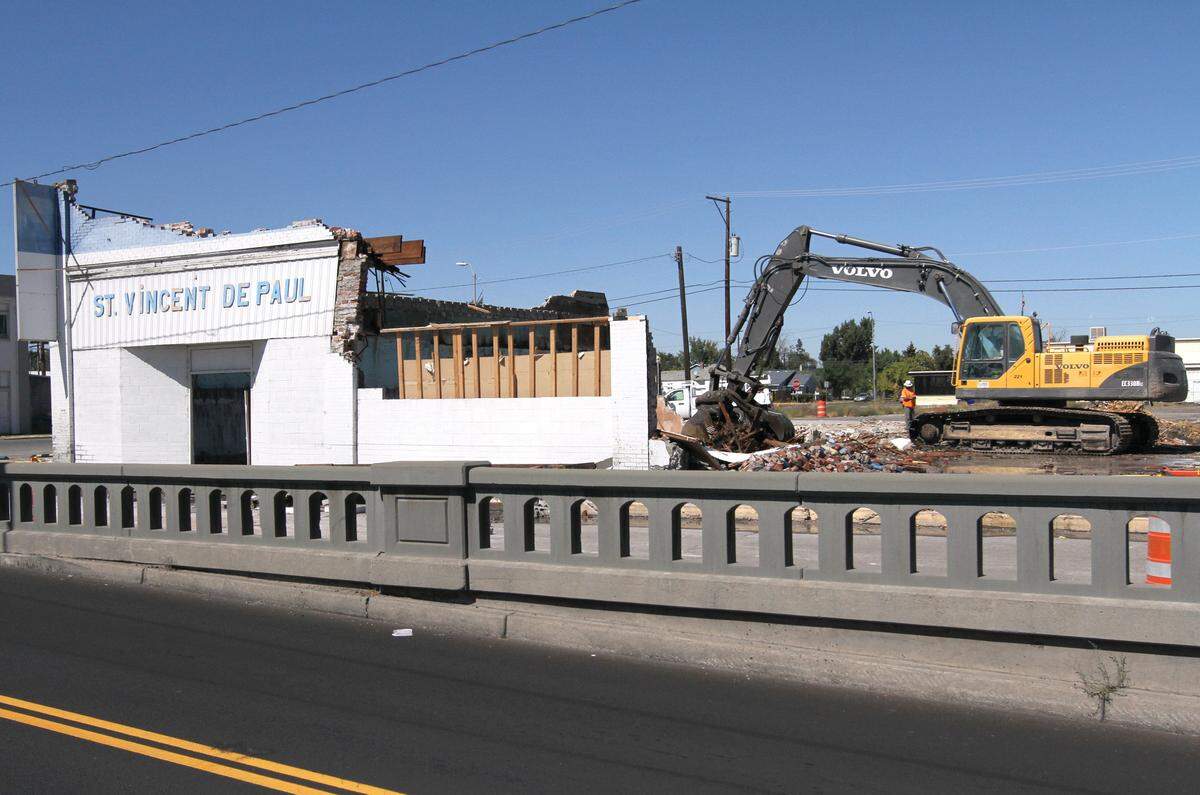 Construction crews demolish the St. Vincent De Paul at the intersection of West Lewis Street and First Avenue in 2014, clearing the way for an overpass to replace the crossing built in 1937 for the BNSF Railway.