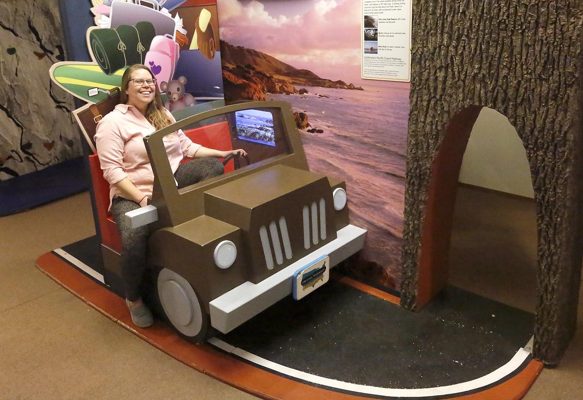 Stephanie Button, Hands In Hands On (HIHO) board member, sits in the car of the California Pacific Coast Highway display that’s part of the Trivial Pursuit, a 50 State Adventure exhibit currently at the East Benton County Historical Museum in Kennewick. The nonprofit is raising money to finish paying for the exhibit. Watch a video at: tricityherald.com/video
