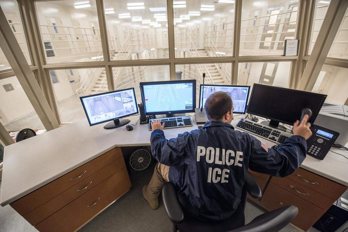 An Immigration and Customs Enforcement officer monitors a detention center.