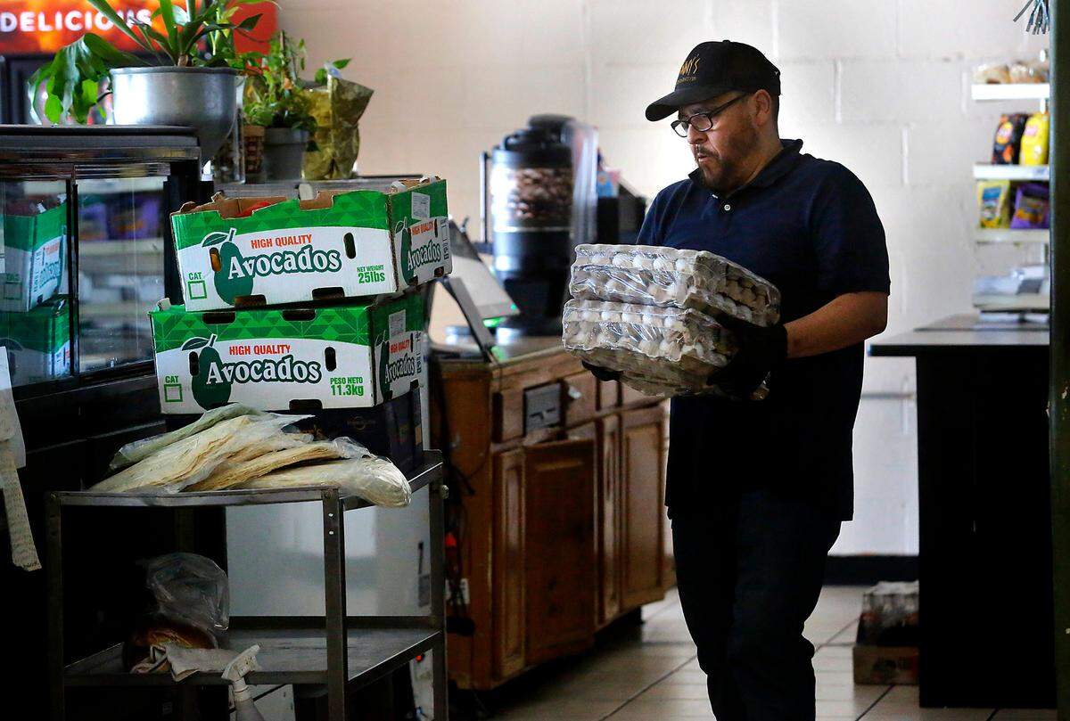 Vinicio “Vinny” Marin Gomez, owner of Vinny’s Bakery & Bistro in downtown Pasco, spends time Thursday morning packaging up leftover food items for donation to a local food bank.