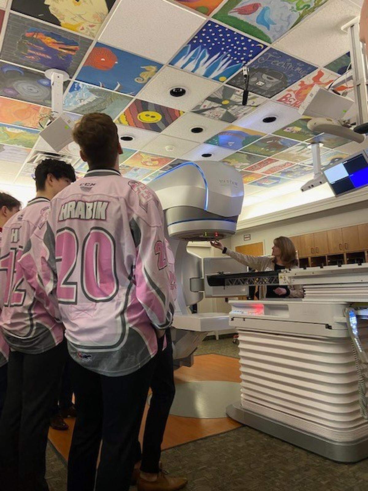 Shelley Cole, a medical dosimetrist at the Tri-Cities Cancer Center, explains to Tri-City Americans players, who toured the center, how she maps out an area on patients for radiation treatments. The Americans will host the Portland Winterhawks on Friday in their 15th annual Breast Cancer Awareness Game at Toyota Center.