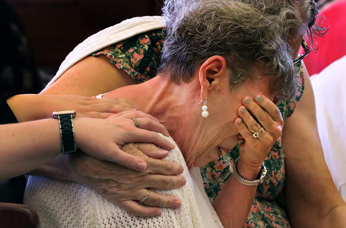 Nancy Lenhart receives a hug and hands of support from family and friends Friday after reading her emotional victim impact statement in Franklin County Superior Court.