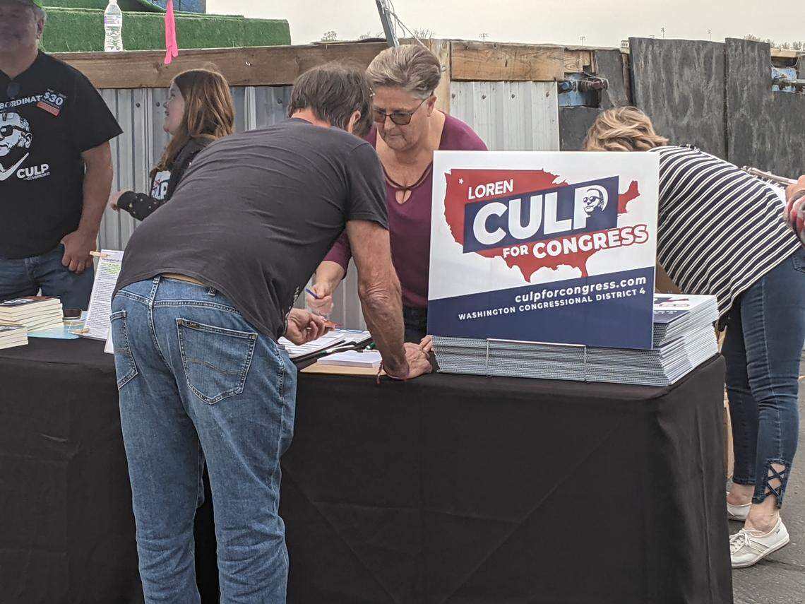 People picked up signs for Loren Culp for Congress at an Ignite the Right Rally in Kennewick.