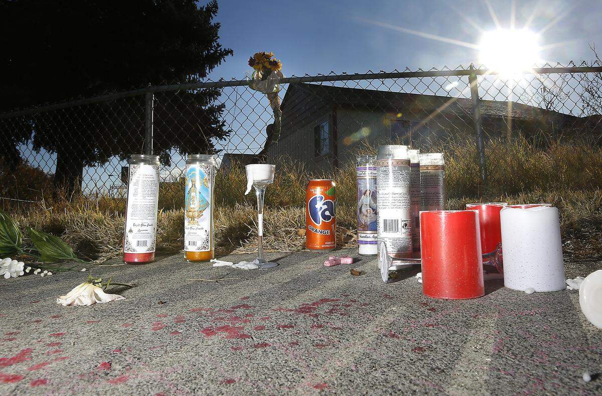 A memorial of candles, flowers and a can of soda for murder victim Hunter Black, 18, is set on the sidewalk outside the fence of the home at 401 S. Yelm St. in Kennewick. The Kennewick police are searching for two suspects in his Oct. 26, 2018 shooting death.