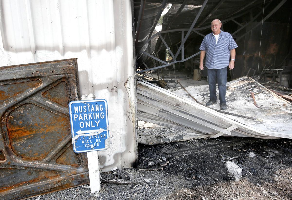 Kennewick resident Gary McCourt  stand just inside the main door of his 30-foot by 50-foot shop building that was destroyed Saturday by a wind-driven brush fire in south Kennewick. His wife, friends and strangers were able to move four vintage Ford Mustangs and a motorcycle to safety before flames spread to the metal building. 