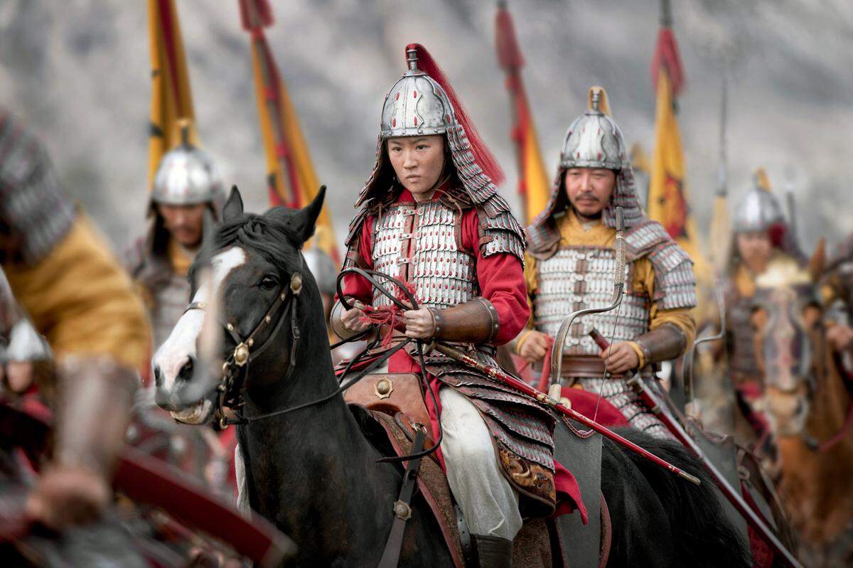 This image released by Disney shows Yifei Liu, center, in the title role of “Mulan.”