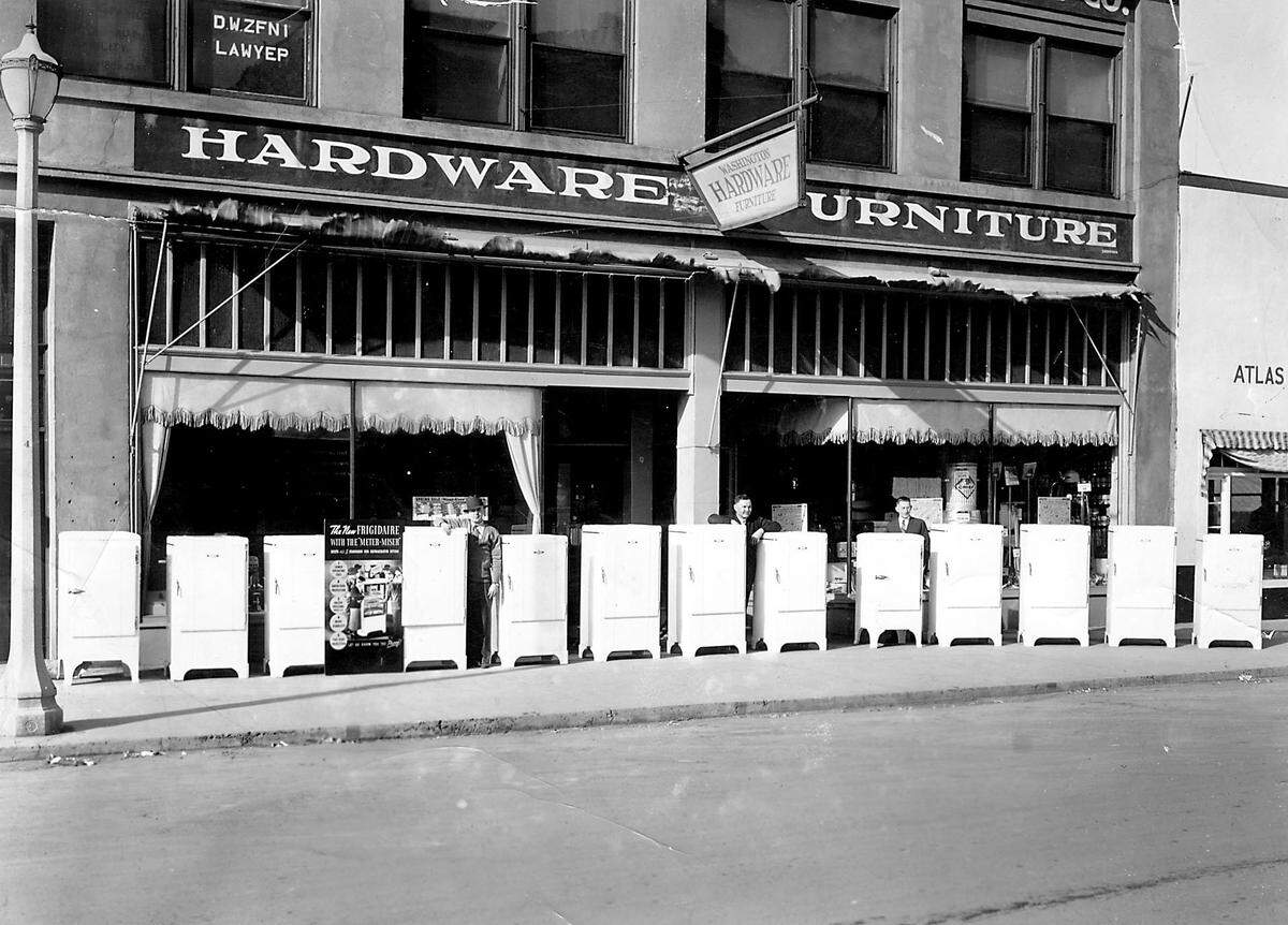 Bill Gravenslund, right, and two unidentified salesmen stand outside of Washington Hardware and Furniture in Kennewick to demonstrate the new Meter Miser Frigidaires in 1933.
