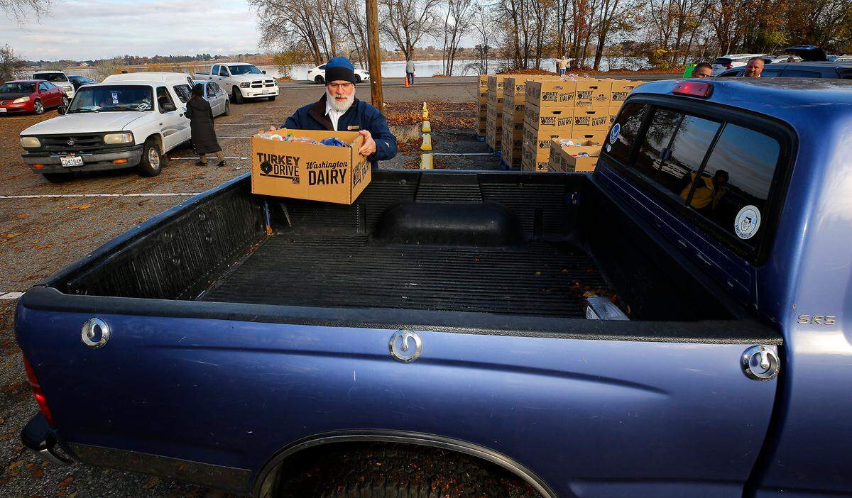Les Schwab Tires employee Bart Hill volunteers loading vehicles at Tuesday’s 2nd Harvest Turkey Drive turkey dinner distribution.