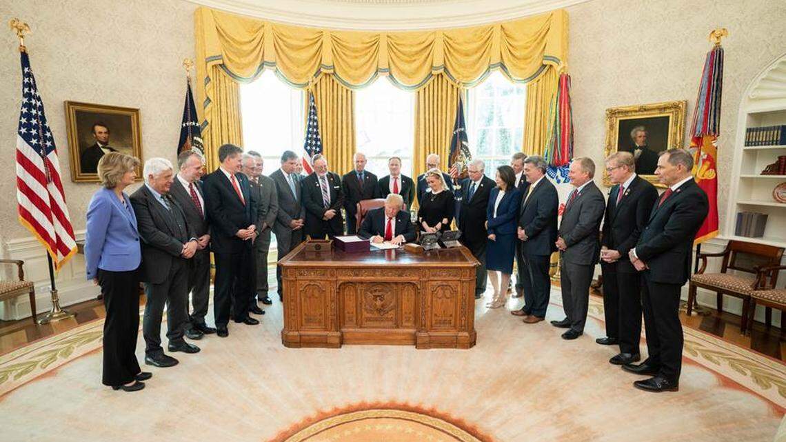President Donald J. Trump, joined by Rep. Debbie Dingell, D- Mich., signs The John D. Dingell, Jr. Conservation, Management and Recreation Act Tuesday, March 12, 2019, in the Oval Office of the White House.  Rep. Dan Newhouse, R-Wash., is on the left and Sen. Maria Cantwell, D-Wash., is on the right.