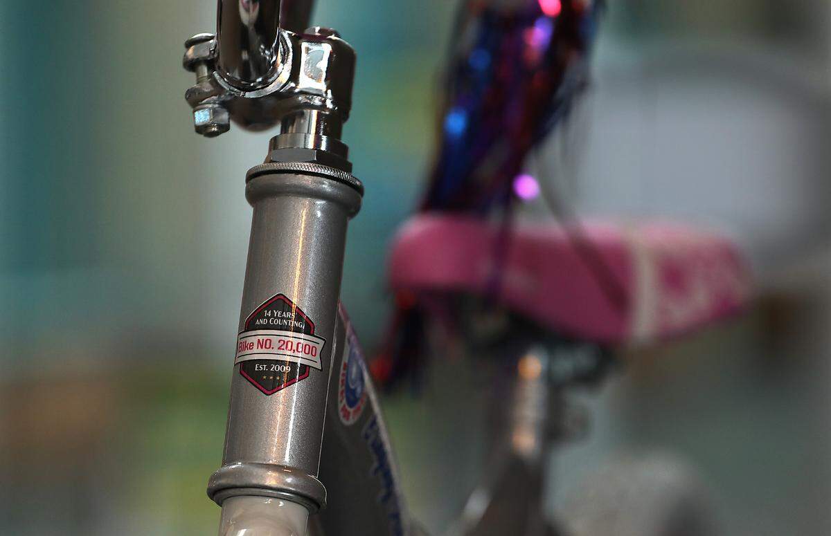 An assembled bicycle on display at the 14th annual Bikes for Tikes bike build event wears a sticker signifying it as the 20,000th bike built for donation by the Bikes for Tikes non-profit organization. It was founded in 2009 by the Plumbers & Steamfitters UA Local 598.