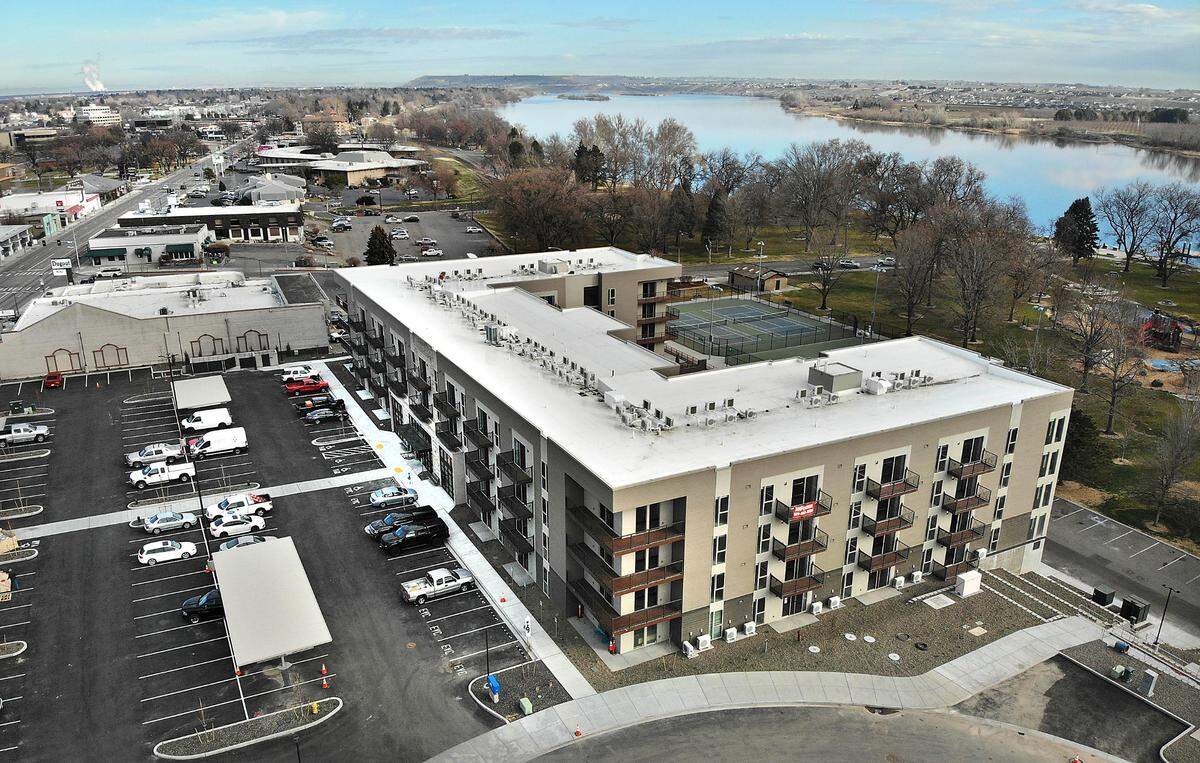 The four-story luxury apartment complex project, situated next to Howard Amon Park along the Columbia River, also includes a pair of retail buildings.