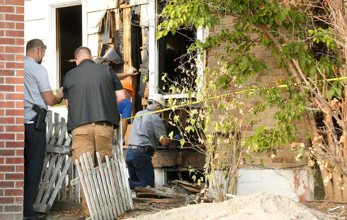 City building inspectors assess the structural integrity of the floor at 220 E. First Ave. damaged by fire. The inspectors were called to determine if it was safe for investigators to enter the home, that has a basement, where a body was discovered by firefighters battling an early morning blaze.