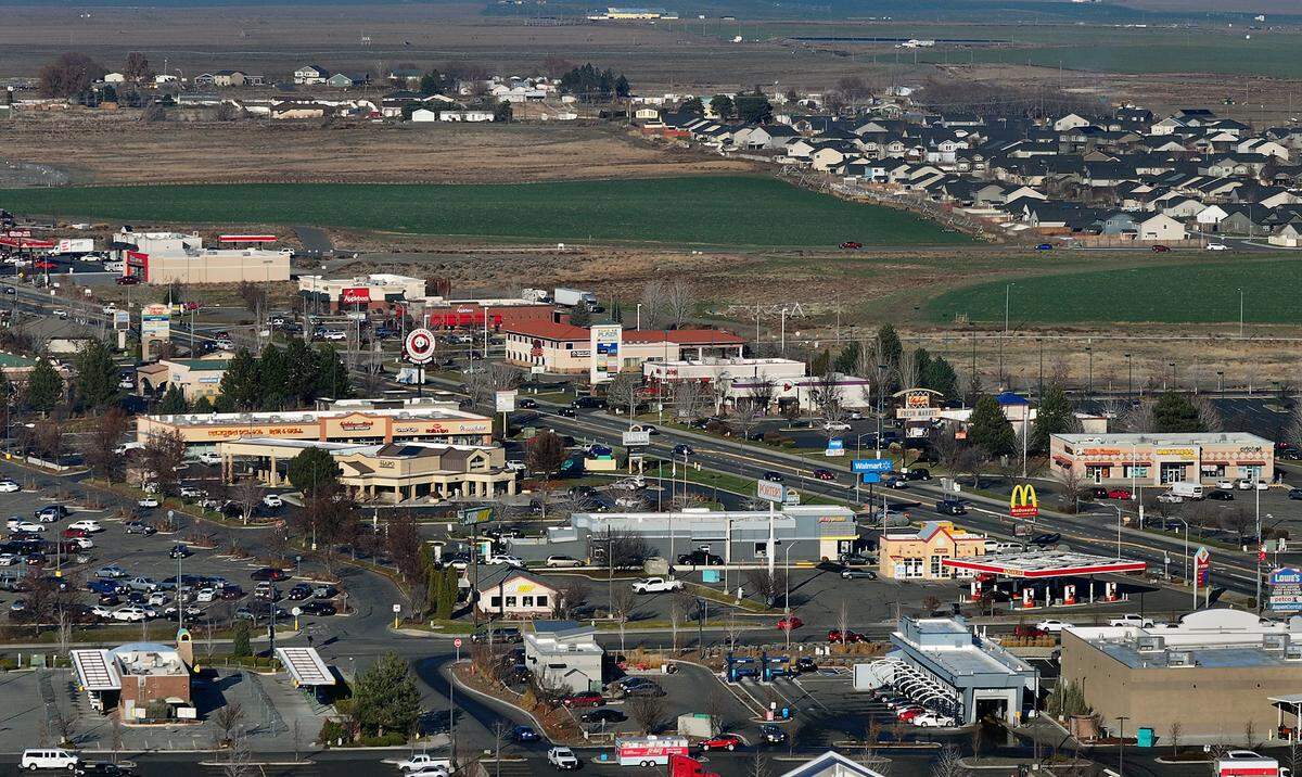 Commercial and retail development and housing with agriculture fields on Road 68 near I-182 interchange in west Pasco. Taken on Dec. 9, 2024.
