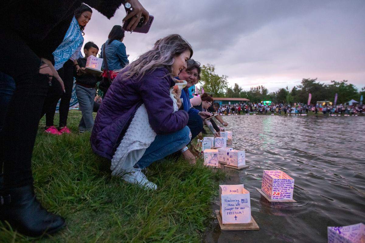 Cynarra Scott hold on to her son tightly as she releases her water lantern into the pond at Columbia Park in 2018.