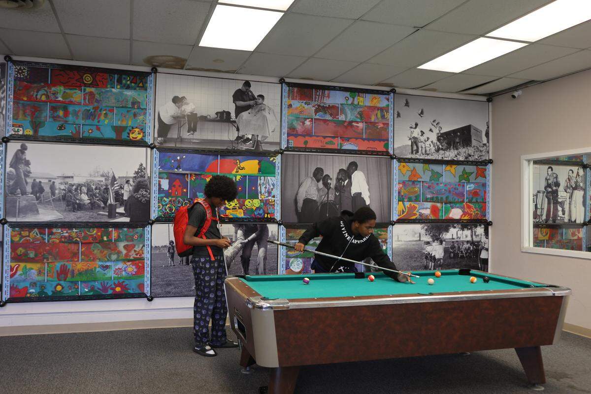 Two teens play pool in the YMCA teen room in the Martin Luther King Jr. Community Center in east Pasco. Some community members are upset about a scaled-back remodel of the aging facility.