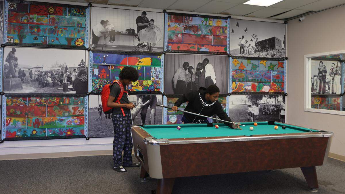 Two teens play pool in the YMCA teen room in the Martin Luther King Jr. Community Center in east Pasco. Some community members are upset about a scaled-back remodel of the aging facility.