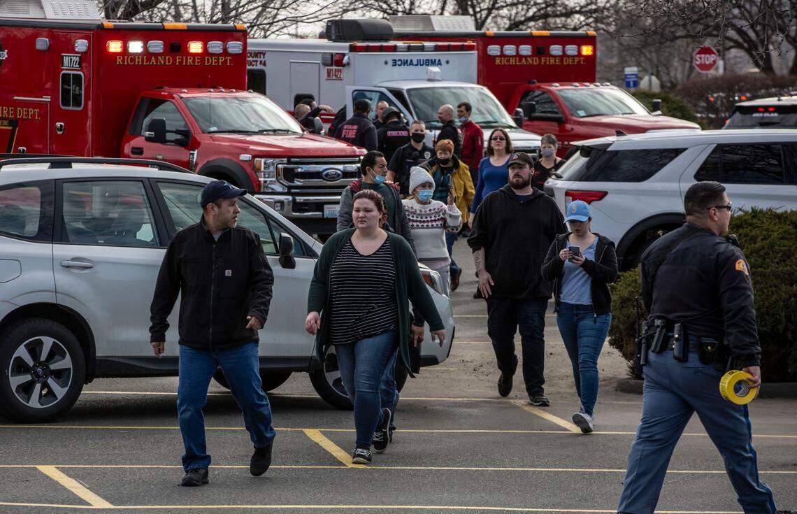 Customers and employees are guided out of the Richland Fred Meyer on Monday morning after a shooting inside the store.