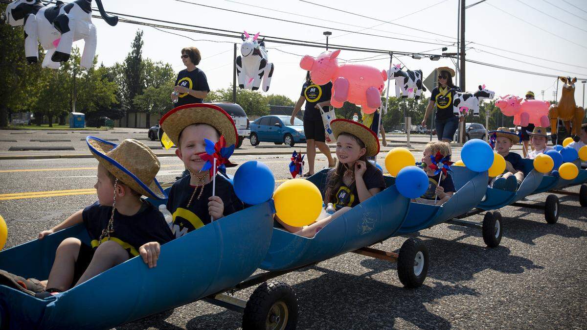 Kids ride in a little barrel train in the the Benton-Franklin Fair & Rodeo Grand Parade on Saturday morning in downtown Kennewick