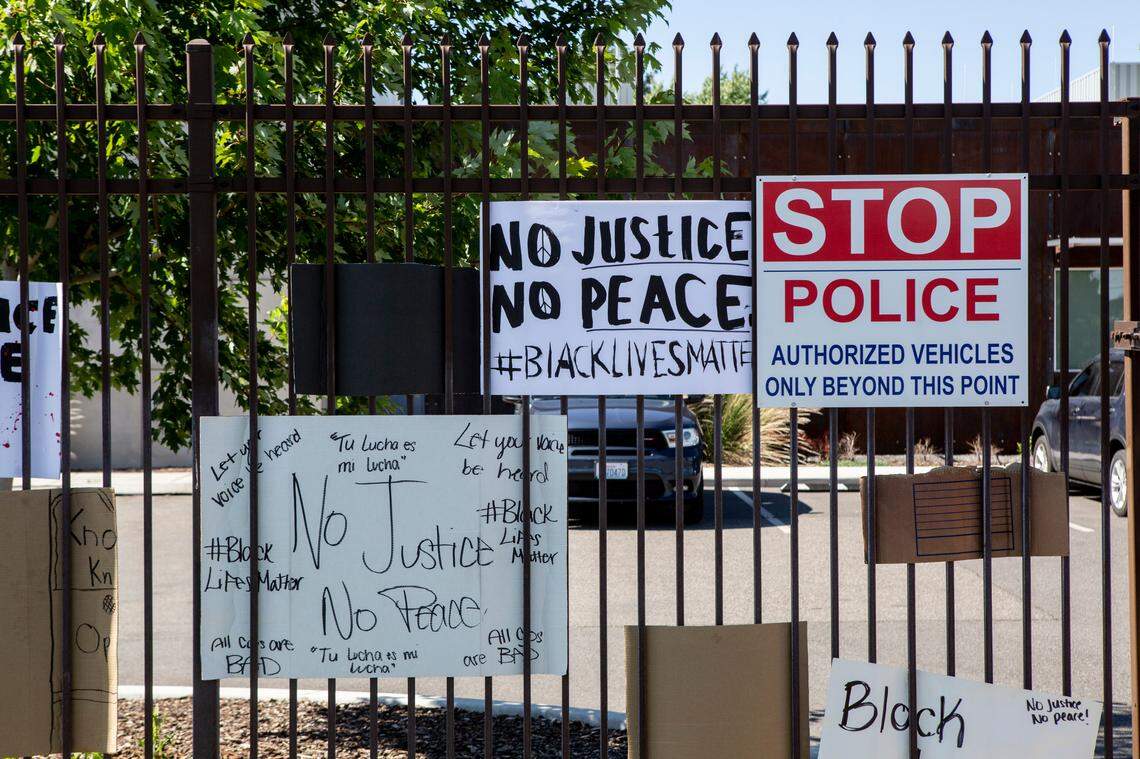 Signs hang on the fence outside the Pasco Police Department on Sunday after a peaceful demonstration against police brutality and violence against black people took place several blocks away on the corner of Court Street and North 20th Street.