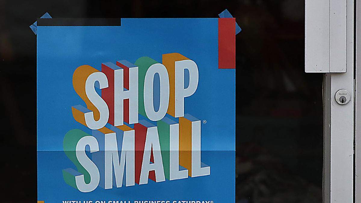 A "Shop Small" sign is displayed on the front door of a business in downtown Kennewick. 